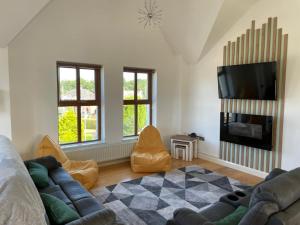 a living room with a couch and a flat screen tv at Orchard Oasis, Luxury Penthouse Getaway in Coleraine