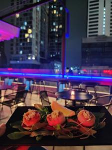 a plate of food on a table with a view of a city at The poshtel Bangkok By Benya BTS Phayathai in Bangkok
