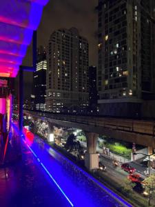 a view of a city at night with a bridge at The poshtel Bangkok By Benya BTS Phayathai in Bangkok