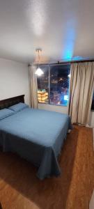 a bedroom with a bed and a window with a city skyline at Depto viña centro in Viña del Mar