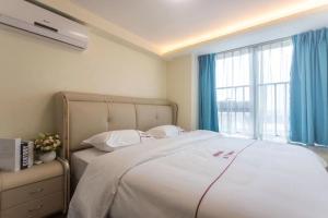 sypialnia z dużym łóżkiem i oknem w obiekcie B T Miele Executive Apartment - Qianhai Square Shenzhen w mieście Shenzhen