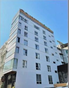 a tall white building with a lot of windows at Gold Dream Hotel in Da Lat