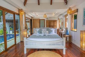 a bedroom with a white bed and a pool at Soul Villas by The Beach - Phuket in Panwa Beach