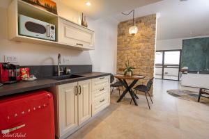 a kitchen with white cabinets and a red appliance at סוויטות נוף לתבור in Giv'at Avni