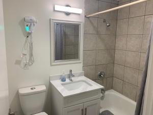 a bathroom with a toilet and a sink and a shower at Destination Inn Cache Creek in Cache Creek