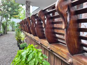 a row of wooden benches with plants on a fence at Hammock Beach Home in Alleppey