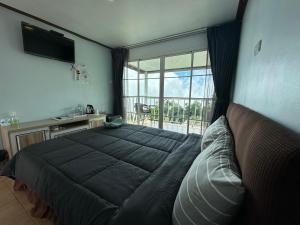 um quarto com uma cama grande e uma janela grande em สเตชั่นภูทับเบิก-บ้านดาดฟ้าทะเลหมอก 