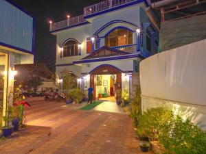 a man standing in front of a house at night at Blossoming Romduol Boutique in Siem Reap
