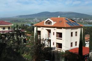 uma casa com um telhado com painéis solares em Gilboa Guest House - Benharim em Gid‘ona