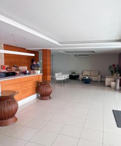 a lobby with a counter and a person in a room at Apartamento de frente para o Mar in Vitória