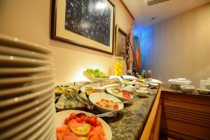a buffet with plates and bowls of food on a counter at Orchid Hotel Al Barsha "Formerly Golden Tulip Hotel Al Barsha" in Dubai