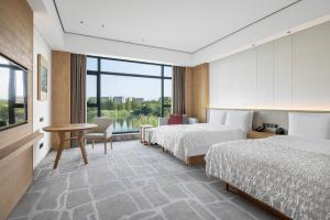 A bed or beds in a room at Le Méridien Emei Mountain Resort