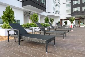 a row of black chairs sitting on a patio at Amber Cove Melaka Icon stay in Melaka