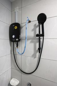 a hose hooked up to a shower in a bathroom at Amber Cove Melaka Icon stay in Melaka