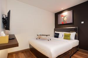 una piccola camera da letto con un letto e una scrivania di Urbanview Hotel Groovy Inn Tangerang a Buaran
