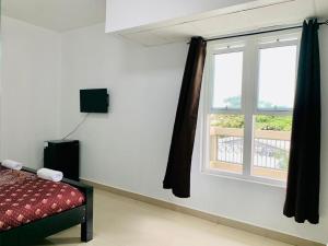 Schlafzimmer mit einem Bett und einem Fenster in der Unterkunft Coastal Bay Suite & Golf Cart Rental in San Pedro