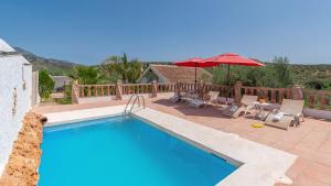 - une piscine avec un parasol, des chaises et une table dans l'établissement Villa Sol Alozaina by Ruralidays, à Alozaina
