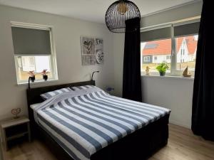 1 dormitorio con 1 cama con rayas azules y blancas en House in Scherpenisse near Oosterschelde, en Scherpenisse