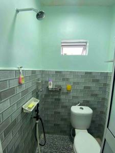 La salle de bains est pourvue de toilettes blanches et d'une fenêtre. dans l'établissement Homestay Naim Sabak Bernam, à Sabak Bernam