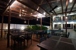 a restaurant with tables and chairs and a pool at Lotus The Lake View Resort in Alibaug