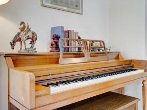 a wooden piano with a statue on top of it at Mid-Century Brick Bungalow Home in Evansville