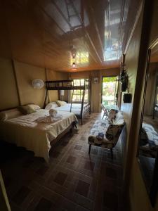 Un dormitorio con 2 camas y una silla. en Tortuguero Hill Rooms, en Tortuguero