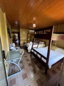 a room with two bunk beds and a table at Tortuguero Hill Rooms in Tortuguero