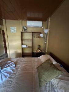 1 dormitorio con cama, lámpara y estante en Tortuguero Hill Rooms, en Tortuguero