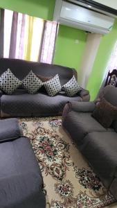 a living room with a brown couch with pillows at Comfort Zone in Montego Bay