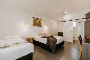 Habitación de hotel con 2 camas y baño en Yeppoon Surfside Motel en Yeppoon
