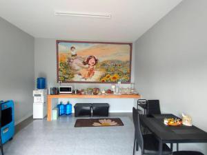 ein Wohnzimmer mit einem Wandgemälde in der Unterkunft โรงแรมดีดีธาราอิน - DD tara inn in Uttaradit