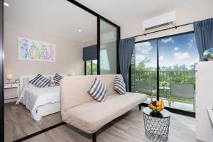 a bedroom with a bed and a couch at The Title Residencies Nai Yang - 1 Bedroom Apartment in Nai Yang Beach +160 photos