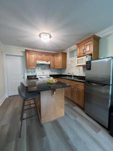 cocina con armarios de madera y nevera de acero inoxidable en Private suite 1 bed 1 bath 15 mins YVR and downtown 舒适安静, en Vancouver