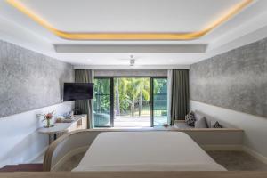 a bedroom with a large bed and a window at Anana Ecological Resort Krabi - SHA Extra Plus in Ao Nang Beach