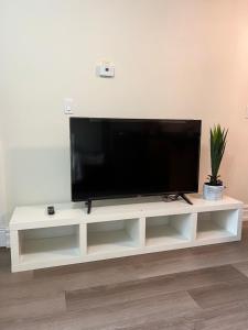 a flat screen tv sitting on top of a white entertainment center at Private suite 1 bed 1 bath 15 mins YVR and downtown 舒适安静 in Vancouver