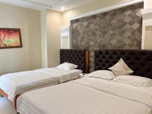 2 nebeneinander sitzende Betten in einem Schlafzimmer in der Unterkunft Royal Hotel in Ho-Chi-Minh-Stadt