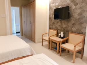 a bedroom with a bed and a tv on a wall at Royal Hotel in Ho Chi Minh City