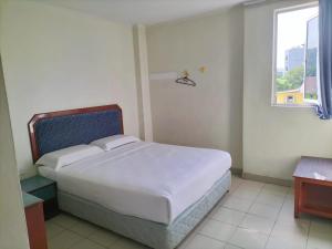 una camera con un grande letto e una finestra di Faber Inn a Bintulu