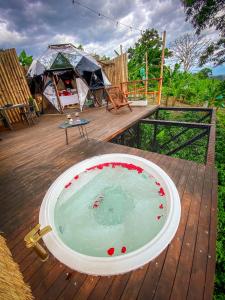 a bath tub on a wooden deck with a tent at Happy Glamping Quindio - Tipo Domo Traslúcido in Calarcá