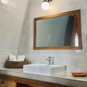ein Waschbecken mit einem Spiegel und einem Korb mit Handtüchern in der Unterkunft Wailanga Resort in Ternate