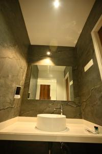 a bathroom with a sink and a mirror at The Sky Land Hotel & Restaurant in Tuljapur