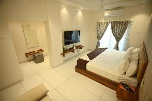 a bedroom with a bed and a television in it at The Sky Land Hotel & Restaurant in Tuljapur