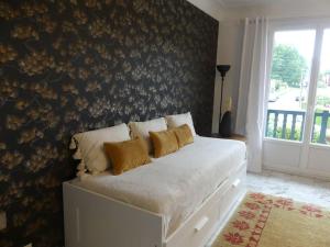 Un dormitorio con una cama blanca con almohadas. en Appartement & jardin vue Rhune, en Ascain