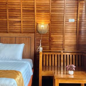 a bedroom with a bed and a table with a lamp at Wailanga Resort in Ternate