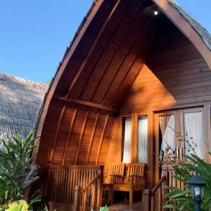 une maison dotée d'une terrasse couverte avec des chaises. dans l'établissement Wailanga Resort, à Ternate