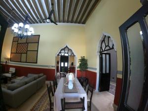 a living room with a table and a couch at Bella Casa Colonial González con Piscina in Campeche