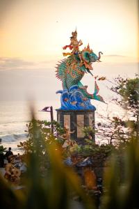 a statue of a dragon sitting on top of the ocean at Sau Bali Beach House Canggu in Canggu