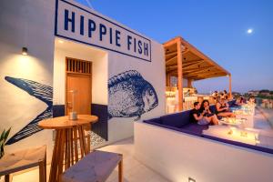 a restaurant with people sitting on a couch on a rooftop at Sau Bali Beach House Canggu in Canggu