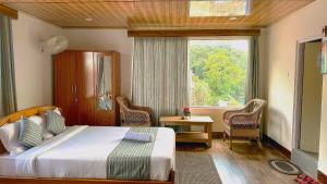 um quarto de hotel com uma cama e uma janela em HOTEL ARMS near SUMI Boys School em Kalimpong