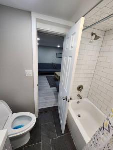 a bathroom with a toilet and a tub and a sink at Vast Stylish Apt Close to NYC! in North Bergen